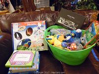 Full view of Symphony-in-Motion mobile box, green bucket with baby toys, Jumping Beans frame, and some boxed items below frame