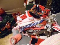 Pile of assorted children's clothing including tops, sweaters, and pants in various colors and patterns.