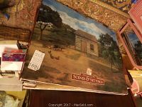 Stack of folded American Girl Scenes & Settings backdrops showing rural log cabin and farmyard with chicken scene on top