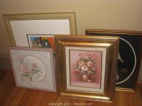 Overall view of the four framed paintings including floral, clown and 3D mother and child pictures.