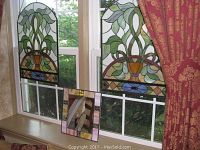 Overall shot of two arched panels and framed mirror displayed in window