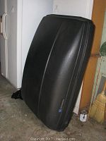 Side view of the black car roof top carrier showing the curved hard-shell surface and overall rectangular shape.