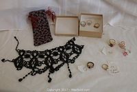 Overview of eight rings and black beaded necklace on white background, with fabric pouch