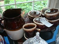 Pitcher, covered bowls, cups on a tray