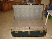 Opened storage trunk showing beige textured fabric interior lining and ample internal storage space.