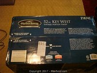 Closed box showing the Harbor Breeze brand, 52 inch Key West model, vintage pewter finish, fragile with glass enclosed, energy saving and UL listed.
