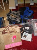 Photo showing multiple backpacks in grey and blue, a beige travel bag, a small burlap tote with pink embellishment, and a packaged back brace.