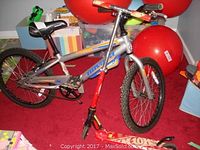 Full side view of Novara 20-inch BMX bike and Hot Wheels scooter together, showing bike frame, tires, and handlebars.