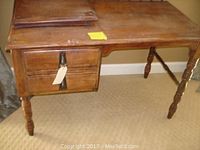 Full view of the vintage wooden desk showing the top, drawers, and legs.