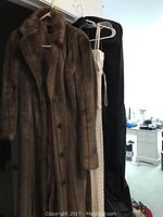 Moda International brown faux fur coat on hanger, full length with button closure.