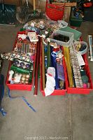 Overview photo showing three large bins filled with various Christmas decorations including ornaments, wrapping paper, and figurines.
