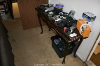 Photo showing the full wooden entry table with various items on top and below it, illustrating size and structure.