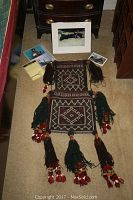 Full view of the Baluch salt bag with symmetrical geometric patterns and tassels, displayed on the floor with the framed Buffalo Boy photo and smaller photos.