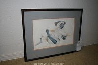 Framed 19x15 colored drawing of reclining man in Mid-East clothing, matted and framed in dark wood frame.