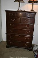 Front view of the Drexel dresser showing six drawers with brass handles and two lamps on top (lamps not included).