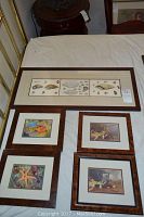 Overview of all five wall art pieces arranged on a bed including one large triple-panel shell print and four smaller framed prints.