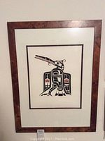 Full view of the framed artwork showing the entire print with dark wood frame and matting.