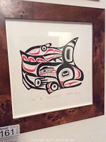 Framed Pacific Northwest Talish artwork showing the Salmon Spirit in red, black, and white, inside dark wood frame.