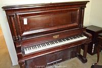 Front view of the upright piano showing wood detail and keys