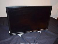 Front view of the Dell 24-inch monitor showing the screen, bezel, and stand on a dark surface.