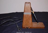 Side view of vintage wooden desk lamp with attached pen holder and power cord.