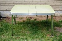 Full view of the vintage kitchen table with double chrome legs and Formica top, showing its proportions and extension feature.