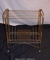 Full front view of brass wire record storage table showing horizontal bars and base compartments