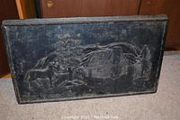 Front view of the rectangular cast iron panel showing a detailed embossed homestead scene with a horse, trees, and house.