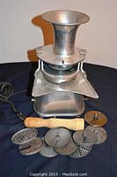 RYP Speed Cutter commercial metal slicer unit with power cord, funnel input, and 9 metal attachments arranged in front along with wooden pusher tool.