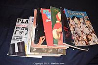 Stack of 12 vintage Playboy magazines with assorted cover designs and colors, some with visible wear on covers and edges.