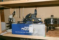 Mastercraft heavy duty angle grinder in box alongside Mastercraft belt sander and other items on shelf