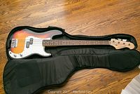 Full view of bass guitar in soft case, showing overall condition and included case