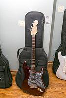 Full front view of guitar leaning against soft gig bag