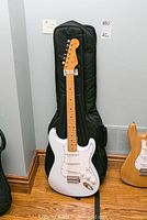 Guitar leaning against soft case showing body