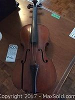 Front view of violin showing the fingerboard, strings, f-holes, and tailpiece.