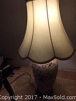 Close-up photo of the decorative lamp featuring floral ceramic base and scalloped shade