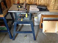 Full view of table saw on stand with manual and blade case on tabletop