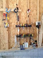 Wide view of hand tools mounted on plywood wall with shelves and clamps