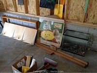 Photo showing wooden Crokinole game board, checkers game box, handmade wooden shelf, and aquarium on floor against wall.