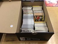 Large box filled with loose sports trading cards arranged upright.