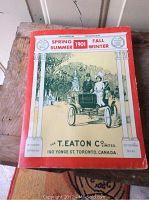 Cover of the 1901 Eaton catalogue reprint showing people in early automobile with decorative columns and printed details.