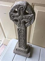 Full view of the upright Celtic cross lawn ornament on a table, showing overall shape and height.