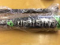 Two black Uprising branded softball bats in original plastic packaging.