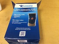 Photo of the Trainers Choice Knee Compression Wrap box showing product information including benefits like reducing swelling, promoting warmth, and providing support to knees.