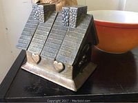 Front view showing the house-shaped playing cards holder with two chimneys and embossed hearts on the front.