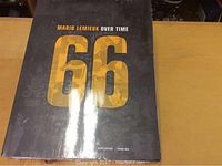 Front cover of the book 'Mario Lemieux Over Time 66' showing the title and number 66 on a black background with gold lettering.