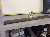 Photo showing the full length of the brass ruler with the soaring eagle handle on top.