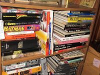 Photo showing the entertainment books on one shelf, including Batman, Superman, and advertising books.