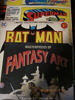 Photo of three publications: Superman limited collector's edition comic book, Batman comic book, and Masterpieces of Fantasy Art book.