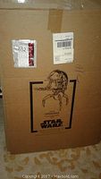 Cardboard box showing printed illustration of life size Droideka from Star Wars Episode One with part number and labeling